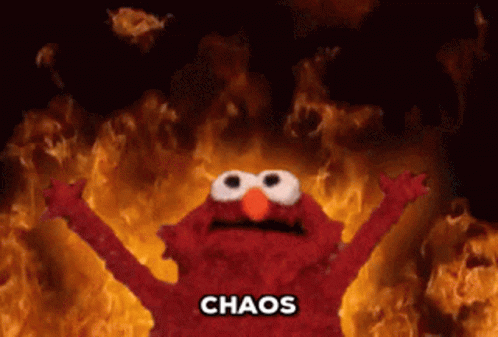elmo with his arms raised in front of a fiery background with a subtitle that says "chaos"