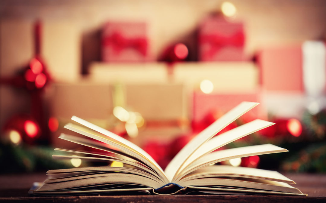 Open book and christmas gift and baubles on background