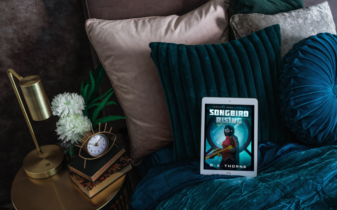 Cover of SONGBIRD RISING on tablet on a luxurious blue velvet bed